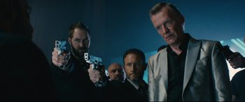 Movie still from “Nobody” (2021), directed by Ilya Naishuller – A group of men standing next to each other holding guns; Medium shot, Low angle