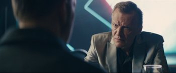 Movie still from “Nobody” (2021), directed by Ilya Naishuller – A man sitting in front of another man in front of a mirror; Close Up shot, Over the shoulder angle