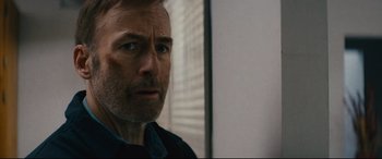 Movie still from “Nobody” (2021), directed by Ilya Naishuller – A man's face in front of a window; Close Up shot, Over the shoulder angle