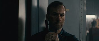 Movie still from “Nobody” (2021), directed by Ilya Naishuller – A person holding a cell phone; Close Up shot, Low angle