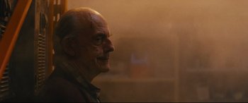 Movie still from “Nobody” (2021), directed by Ilya Naishuller – An old man with a bald head looking to his left; Close Up shot, Over the shoulder angle