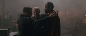 Movie still from “Nobody” (2021), directed by Ilya Naishuller – A group of men standing next to each other in a room; Medium shot, High angle