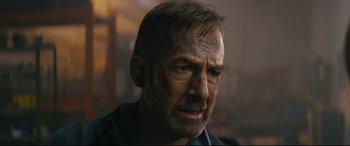 Movie still from “Nobody” (2021), directed by Ilya Naishuller – A person wearing a shirt; Close Up shot, Over the shoulder angle