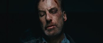 Movie still from “Nobody” (2021), directed by Ilya Naishuller – A person with blood on his face; Close Up shot, Overhead angle