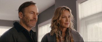 Movie still from “Nobody” (2021), directed by Ilya Naishuller – A man and a woman standing next to each other in a room; Close Up shot, Over the shoulder angle