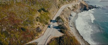 Movie still from “Nobody” (2021), directed by Ilya Naishuller – An aerial view of an rv driving down a road; Extreme Wide shot, High angle