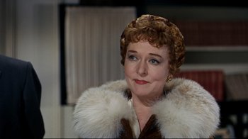 Movie still from “North by Northwest” (1959), directed by Alfred Hitchcock – An older woman wearing a fur coat and a hat; Close Up shot, Over the shoulder angle