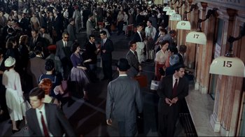 Movie still from “North by Northwest” (1959), directed by Alfred Hitchcock – A group of people standing in a room; Wide shot, High angle