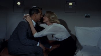 Movie still from “North by Northwest” (1959), directed by Alfred Hitchcock – A man and a woman are kissing in a room; Medium shot, Overhead angle