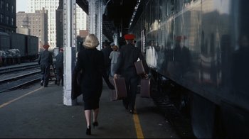 Movie still from “North by Northwest” (1959), directed by Alfred Hitchcock – A man and a woman walking down a train platform holding suitcases; Wide shot, Over the shoulder angle