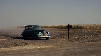 Movie still from “North by Northwest” (1959), directed by Alfred Hitchcock – An old car parked on the side of the road; Extreme Wide shot, High angle