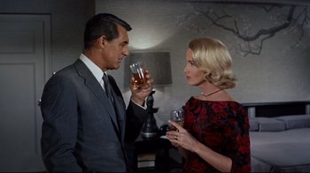 Movie still from “North by Northwest” (1959), directed by Alfred Hitchcock – A man and a woman holding glasses of wine; Medium shot, Low angle