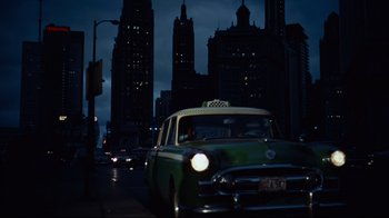 Movie still from “North by Northwest” (1959), directed by Alfred Hitchcock – A taxi cab driving down a street at night; Extreme Wide shot, Low angle