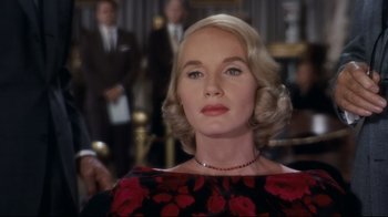 Movie still from “North by Northwest” (1959), directed by Alfred Hitchcock – A woman with blonde hair wearing a black and red dress; Close Up shot, Over the shoulder angle