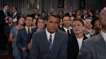 Movie still from “North by Northwest” (1959), directed by Alfred Hitchcock – Many people sitting in a large room together; Medium shot, Over the shoulder angle