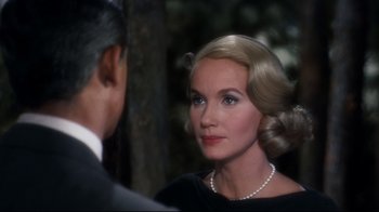 Movie still from “North by Northwest” (1959), directed by Alfred Hitchcock – An older woman wearing a black dress with a pearl necklace; Close Up shot, Over the shoulder angle