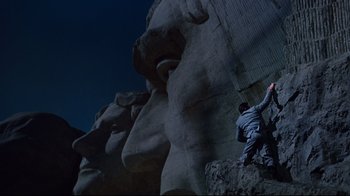 Movie still from “North by Northwest” (1959), directed by Alfred Hitchcock – Two people climbing a rock face at night; Extreme Wide shot, Low angle