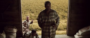 Movie still from “O Brother, Where Art Thou?” (2000), directed by Joel Coen – A man in a striped shirt is standing in front of another man; Wide shot, High angle