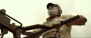 Movie still from “O Brother, Where Art Thou?” (2000), directed by Joel Coen – An old man holding a baseball bat in his hands; Close Up shot, Low angle