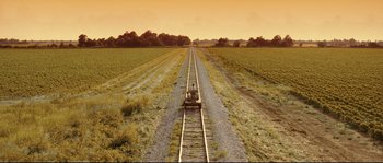 Movie still from “O Brother, Where Art Thou?” (2000), directed by Joel Coen – An empty train track in the middle of a field; Extreme Wide shot, High angle