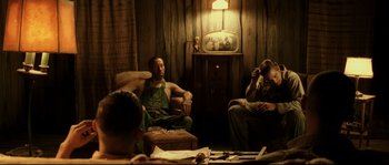 Movie still from “O Brother, Where Art Thou?” (2000), directed by Joel Coen – A group of people sitting in a room; Medium shot, Low angle