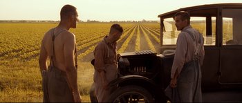 Movie still from “O Brother, Where Art Thou?” (2000), directed by Joel Coen – Two men stand in front of an old car in the middle of a field; Medium shot, Over the shoulder angle