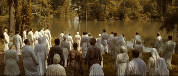 Movie still from “O Brother, Where Art Thou?” (2000), directed by Joel Coen – A group of people standing in front of a body of water; Extreme Wide shot, High angle