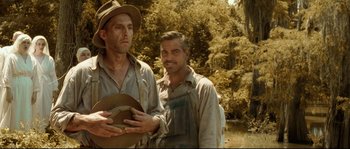 Movie still from “O Brother, Where Art Thou?” (2000), directed by Joel Coen – Two men standing next to each other in a field; Medium shot, Low angle