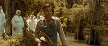 Movie still from “O Brother, Where Art Thou?” (2000), directed by Joel Coen – A man standing next to a body of water; Medium shot, Over the shoulder angle