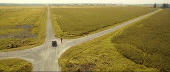 Movie still from “O Brother, Where Art Thou?” (2000), directed by Joel Coen – An aerial view of an empty road with a car on it; Extreme Wide shot, High angle