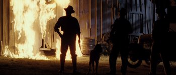 Movie still from “O Brother, Where Art Thou?” (2000), directed by Joel Coen – Two men and a dog standing in front of a fire; Wide shot, Low angle
