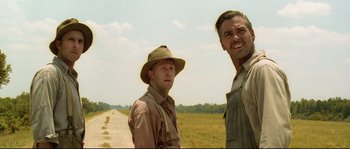 Movie still from “O Brother, Where Art Thou?” (2000), directed by Joel Coen – Two men standing next to each other on a dirt road; Medium shot, Low angle
