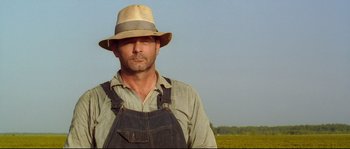 Movie still from “O Brother, Where Art Thou?” (2000), directed by Joel Coen – A man wearing a straw hat standing in a field; Close Up shot, Low angle
