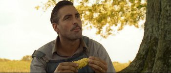 Movie still from “O Brother, Where Art Thou?” (2000), directed by Joel Coen – A man holding a corn cob in his hands; Close Up shot, Low angle