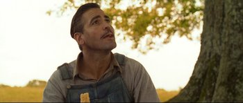 Movie still from “O Brother, Where Art Thou?” (2000), directed by Joel Coen – A man with a beard is looking up at a tree; Close Up shot, Low angle