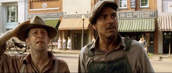 Movie still from “O Brother, Where Art Thou?” (2000), directed by Joel Coen – A man and a woman standing on the side of the street; Close Up shot, Low angle