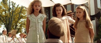 Movie still from “O Brother, Where Art Thou?” (2000), directed by Joel Coen – Two young girls standing next to each other in front of an older man; Medium shot, Over the shoulder angle