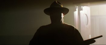 Movie still from “O Brother, Where Art Thou?” (2000), directed by Joel Coen – A man wearing a hat and a brown jacket; Close Up shot, Low angle