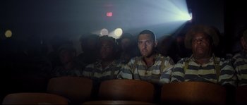 Movie still from “O Brother, Where Art Thou?” (2000), directed by Joel Coen – A group of people sitting in a room; Medium shot, Low angle