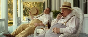 Movie still from “O Brother, Where Art Thou?” (2000), directed by Joel Coen – A group of men sitting on a porch; Medium shot, Low angle