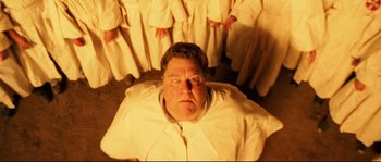 Movie still from “O Brother, Where Art Thou?” (2000), directed by Joel Coen – A man in a white shirt is surrounded by a group of people; Medium shot, Overhead angle