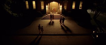 Movie still from “O Brother, Where Art Thou?” (2000), directed by Joel Coen – A group of people standing on steps in front of a building at night; Extreme Wide shot, High angle