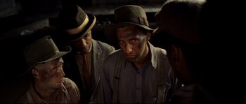 Movie still from “O Brother, Where Art Thou?” (2000), directed by Joel Coen – A group of men wearing hats and looking at the camera; Close Up shot, High angle