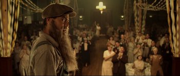 Movie still from “O Brother, Where Art Thou?” (2000), directed by Joel Coen – A man with a long beard standing in front of a group of people; Close Up shot, Low angle