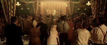 Movie still from “O Brother, Where Art Thou?” (2000), directed by Joel Coen – A group of people standing in front of a stage; Wide shot, High angle