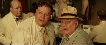Movie still from “O Brother, Where Art Thou?” (2000), directed by Joel Coen – Two men are posing for a picture in a restaurant; Close Up shot, Low angle
