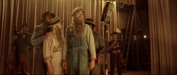 Movie still from “O Brother, Where Art Thou?” (2000), directed by Joel Coen – A group of people standing in front of microphones; Medium shot, Low angle