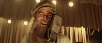 Movie still from “O Brother, Where Art Thou?” (2000), directed by Joel Coen – An old man with a long beard is smiling; Close Up shot, Low angle