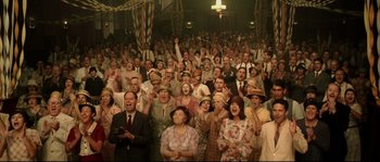 Movie still from “O Brother, Where Art Thou?” (2000), directed by Joel Coen – A group of people that are standing up in a room; Wide shot, High angle
