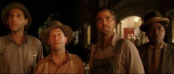 Movie still from “O Brother, Where Art Thou?” (2000), directed by Joel Coen – A couple of men standing next to each other on a street; Medium shot, Low angle